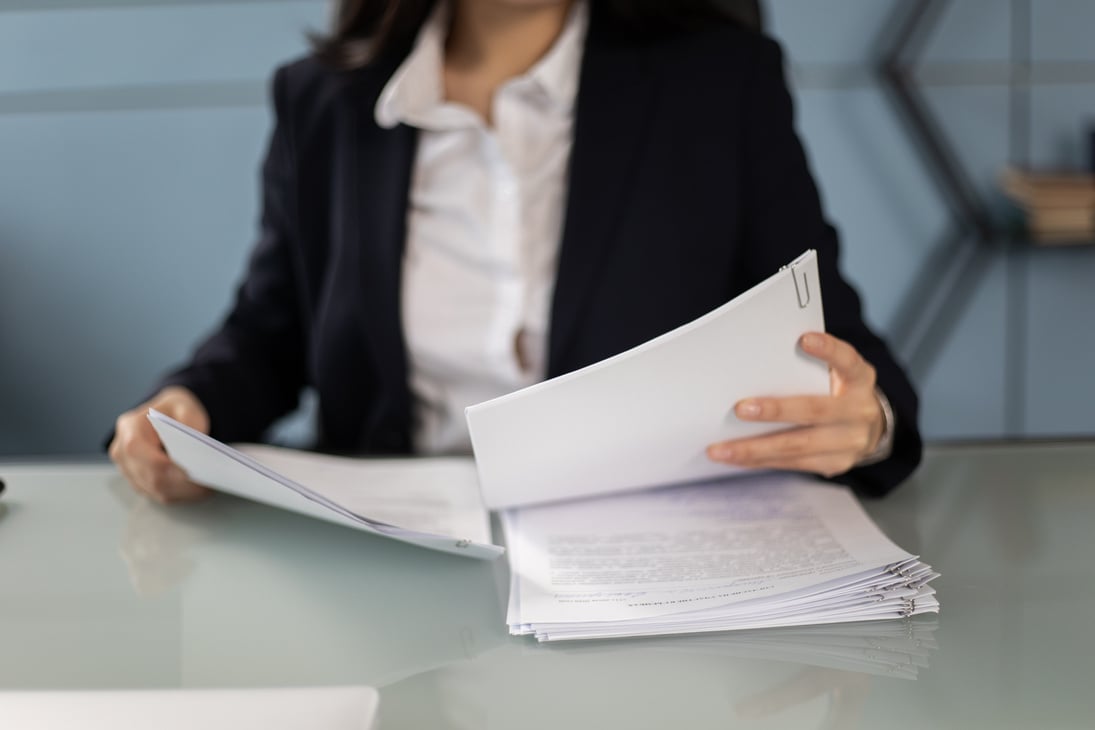 Person in Black Blazer Holding Papers 